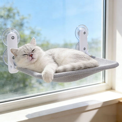 Foldable cat hammock with suction cups hanging in a sunny window, wall-mounted cat sunbathing and climbing bed from A minha loja.
